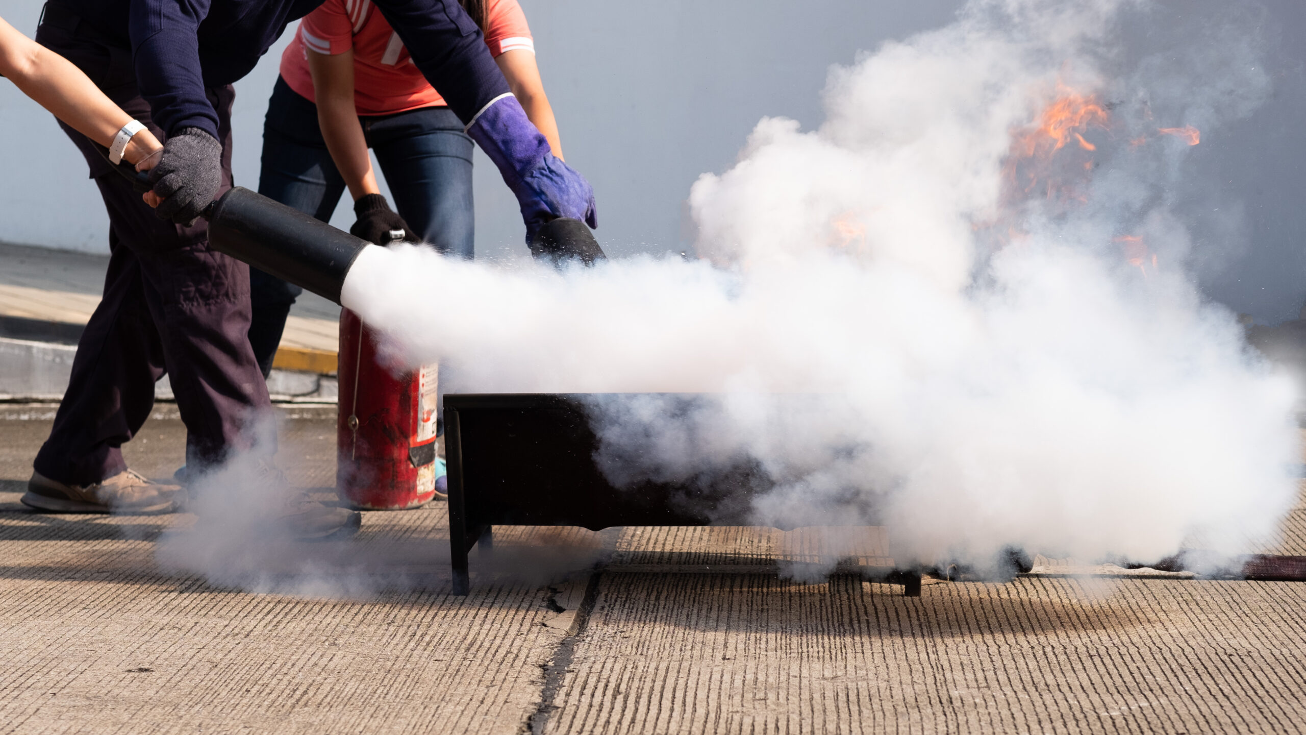 instructeur qui montre comment éteindre le feu